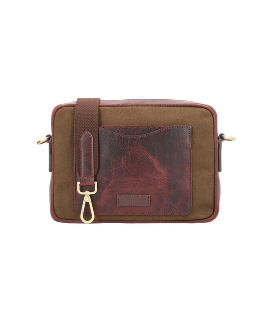 Studio Ek Inch Metropolitan Sling crossbody bag crafted from waterproof canvas and reclaimed leather with an adjustable shoulder strap and back pocket for carrying a phone, passport and travel essentials. A premium sling bag designed for modern journeys.
