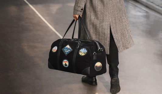 Man walking with premium canvas leather duffle bag, stylish weekender bag for men, ideal for airport travel, business trips, and modern minimal travel lifestyle