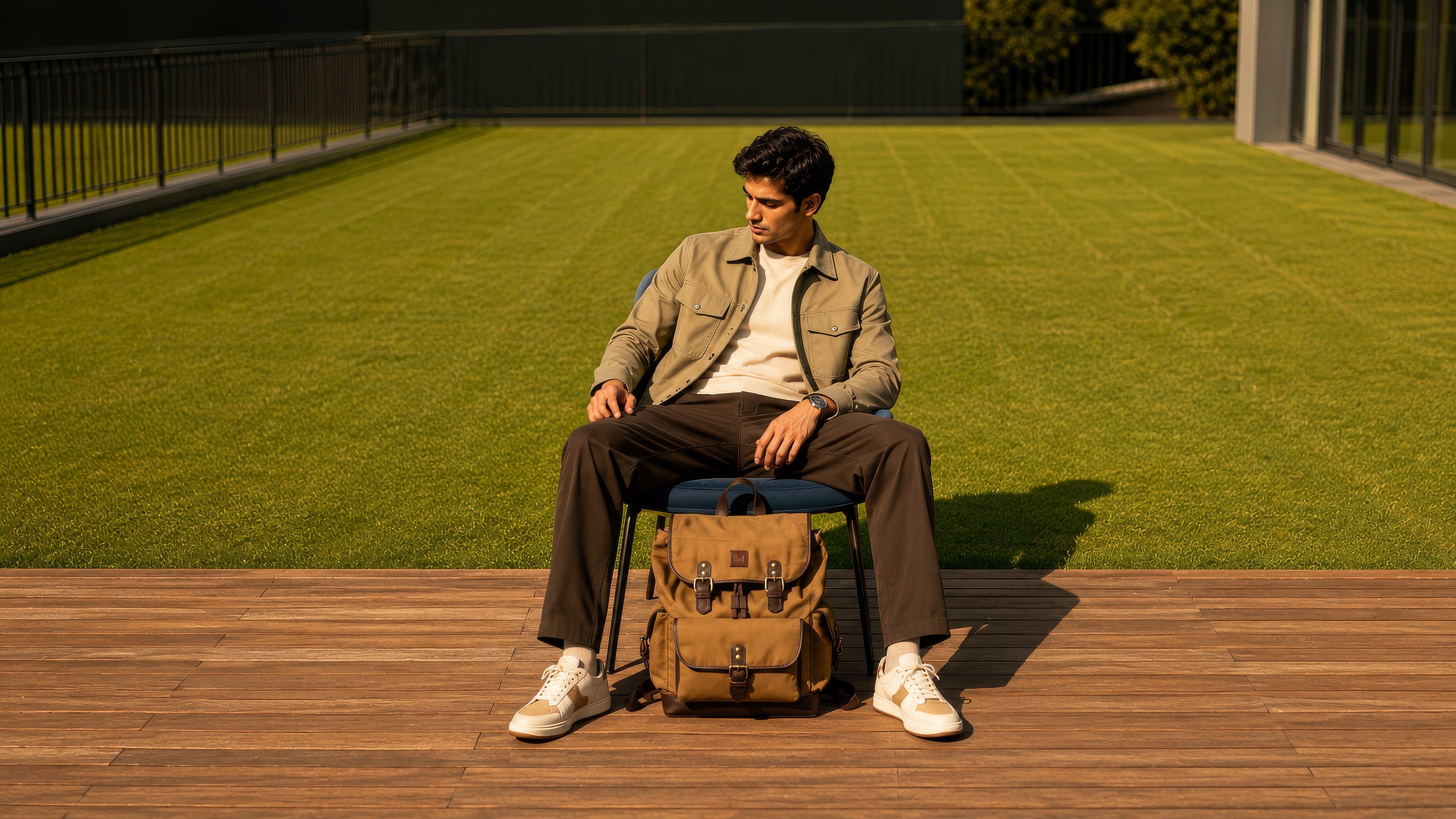 Man relaxing outdoors with the Explorer Series tan canvas and reclaimed leather drawstring backpack, showcasing an everyday travel and lifestyle setting.