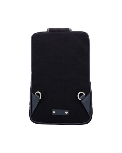 Black canvas and reclaimed leather mini crossbody backpack with padded shoulder pad, adjustable strap, iPad sleeve, and ergonomic design for everyday carry, silver nickel fittings