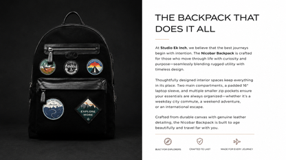 Studio Ek Inch Nicobar backpack in navy waterproof canvas with utility pockets and travel-inspired patches, displayed on a stack of books. Designed as a premium travel backpack and rucksack for men, it combines durable craftsmanship with everyday functionality and vintage aesthetics.