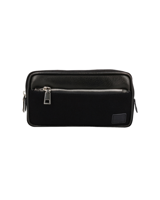 Studio Ek Inch Urban Traveller crossbody bag in black canvas and reclaimed leather with multiple zip compartments and an adjustable shoulder strap. Designed as a minimalist travel bag and canvas sling bag for men, it offers organized storage for everyday essentials and reflects the craftsmanship of one of the best backpack brands in India.