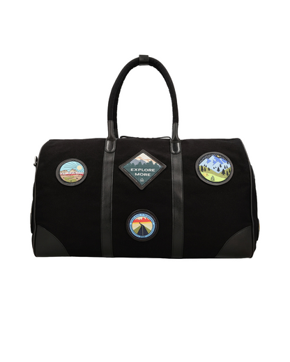 Front view of the Studio Ek Inch Kasol weekender duffle bag in black canvas and reclaimed leather, featuring handcrafted travel-inspired patches and spacious interiors. This premium canvas and leather hold all bag is designed for weekend getaways, airport travel and overnight trips by one of India's premium bag brands.