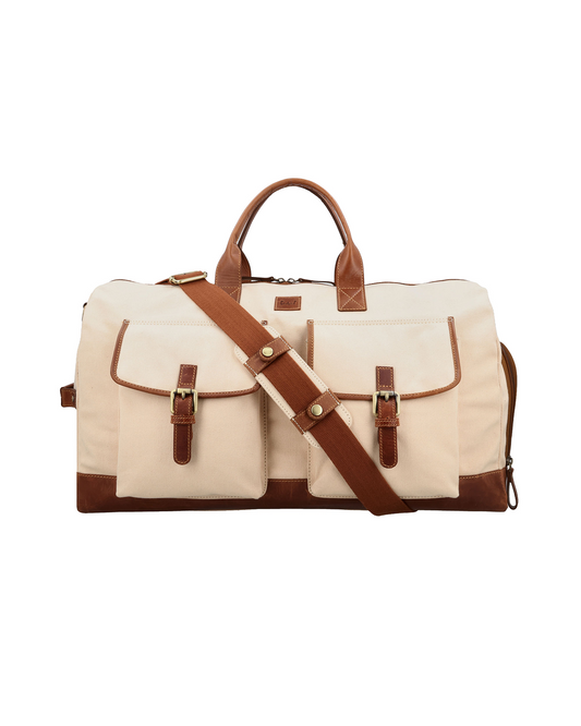Front view of the Studio Ek Inch Rohtang weekender duffle bag in natural canvas and reclaimed leather with dual front pockets and an adjustable shoulder strap. This premium canvas and leather travel bag is designed for weekend getaways, airport travel and overnight trips by one of India's premium bag brands.