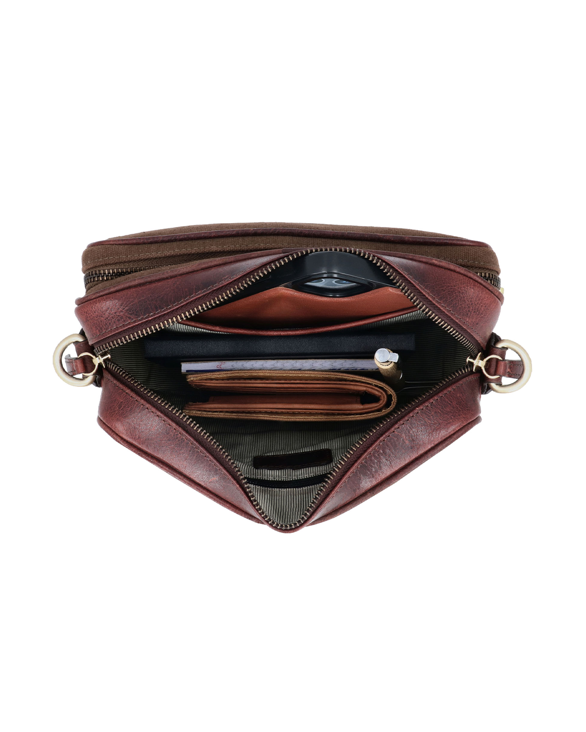 Top view of the Studio Ek Inch Metropolitan Sling bag in waterproof canvas and reclaimed leather, showing organized compartments for a smartphone, wallet, notebook, charger and everyday essentials. Designed as a premium crossbody bag for travel and daily use with spacious, easy-access storage.
