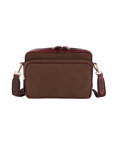 Front view of the Studio Ek Inch Metropolitan Sling bag in brown waterproof canvas and reclaimed leather, featuring a spacious zip pocket, adjustable shoulder strap and antique brass hardware. Designed as a premium crossbody bag for travel and everyday use, it offers practical storage with timeless craftsmanship.