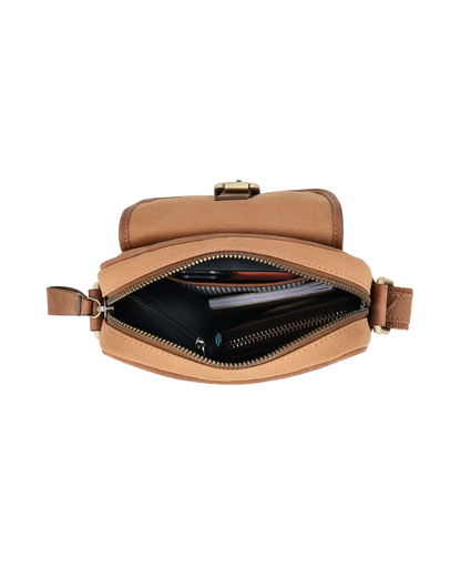 Top view of the Studio Ek Inch River Sling bag showing spacious compartments for a smartphone, wallet, notebook and daily essentials. Crafted from waterproof canvas and reclaimed leather for modern travel. premium crossbody 