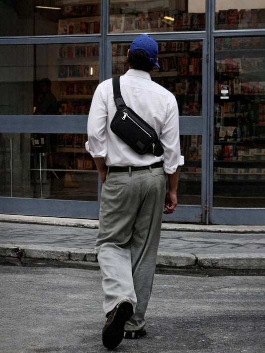 A man carrying the Studio Ek Inch Urban Traveller black canvas and leather shoulder crossbody bag. Designed for modern travel and everyday movement, this crossbody sling bag combines minimalist design, practical storage and handcrafted detailing from one of the best crossbody bag brands in India.